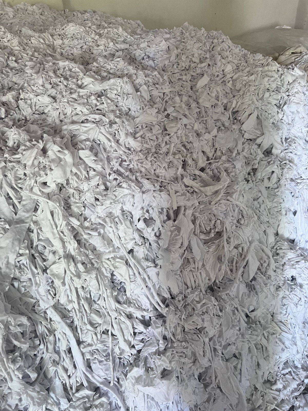 Pre-consumer textile waste — cotton cuttings ready for recycling